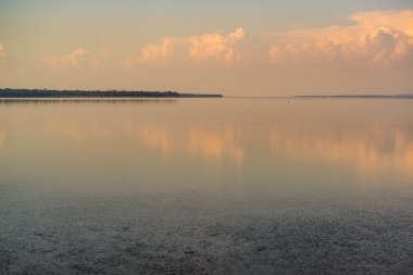 Itaipu Baraj Gölü, Foz do Iguau, Parana, Brezilya 19 Mayıs 2015. Öğleden sonra turuncu renkli bulutlar, suya yansıyor..