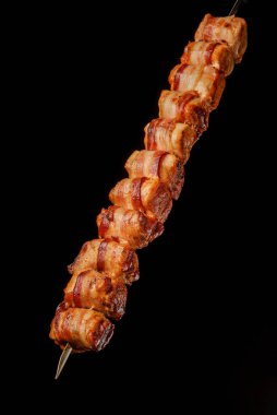 Siyah arka planda domuz pastırmalı ızgara hindi göğsü. Brezilya gastronomisi.