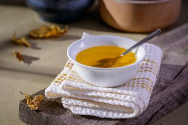 Hindistan 'dan gelen Ghee yağı ahşap masadaki beyaz yemek kabında..