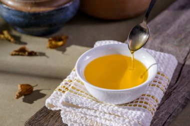 Hindistan 'dan gelen Ghee yağı ahşap masadaki beyaz yemek kabında..