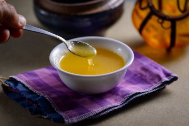 Hindistan 'dan gelen Ghee yağı ahşap masadaki beyaz yemek kabında..