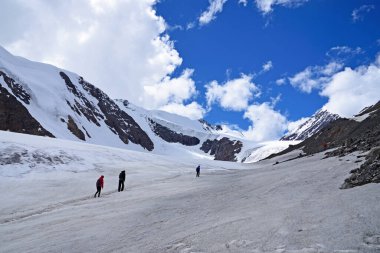 Turistler Altai dağlarındaki Severo-Chuisky sırtındaki Aktru buzuluna tırmanıyorlar..