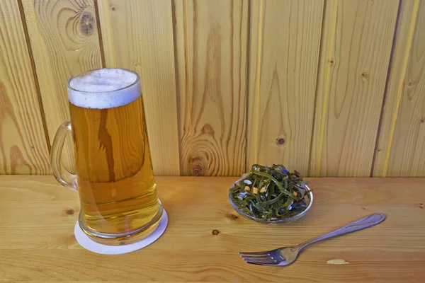 Bir kupa bira ve yosunlu bir fincan çay tabağı..