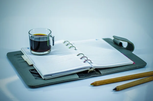 Black coffee on notebook — Stock Photo, Image