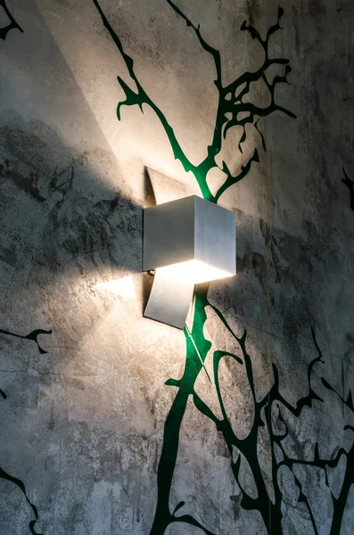 Modern lamp on tree painted wall — Stock Photo, Image