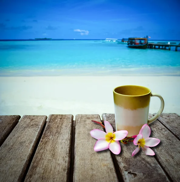 Tazza da caffè su vecchio tavolo in legno posto sulla spiaggia — Foto Stock