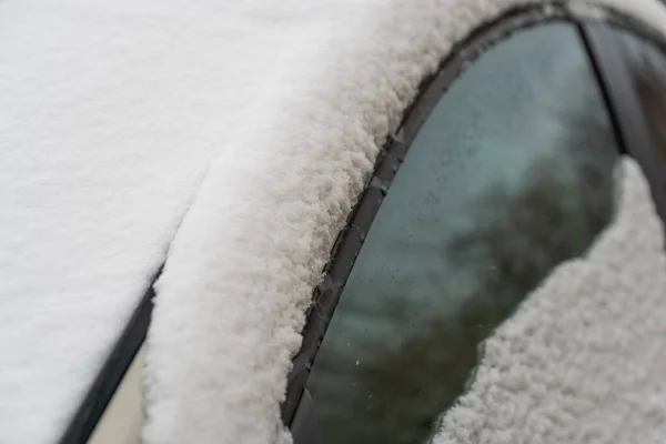 Snow covered car. Melting snow on car in warm winter morning. Concept of driving in winter time with snow on road. Winter season. Copy space.