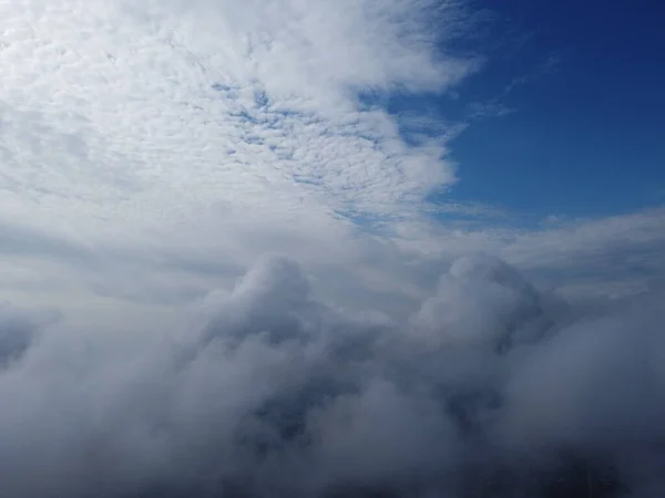 High above the thick fog, like beautiful ocean of clouds at sunrise. Sun is rising above the endless sea of clouds until the horizon. Amazing nature landscape