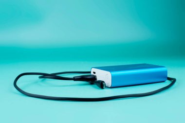 Mavi arka planda siyah kablo ile mavi güç bankası