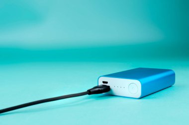 Mavi arka planda siyah kablo ile mavi güç bankası