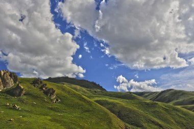 Yeşil çimenlerin üzerinde hill ve bulutlar