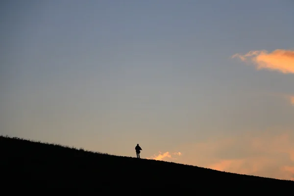 Silhouette of a man walking away in sunset — Stock Photo, Image