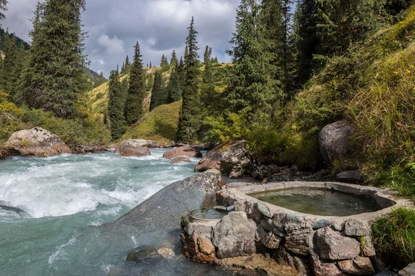 Hotsprings em forma de coração perto do rio da montanha Fotos De Bancos De Imagens Sem Royalties