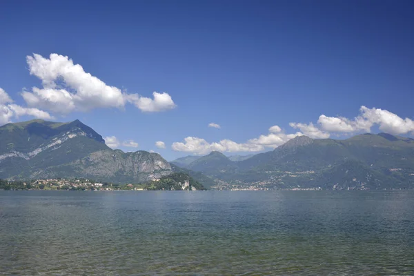 Pozioma panorama świeżego jeziora Como otoczona wzgórzami pokrytymi zielonym lasem cedrowym — Zdjęcie stockowe