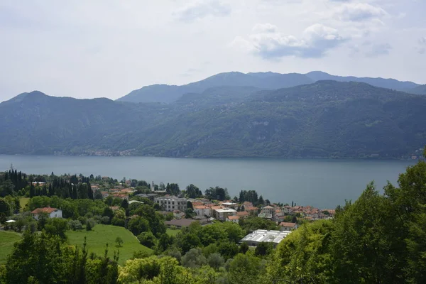 Panorama du lac de montagne de Côme entouré de collines verdoyantes couvertes de forêts de cèdres — Photo