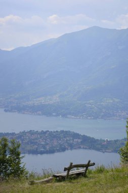 Tahta bank uzak göl manzaralı tepe kenarında dikey duruyor.