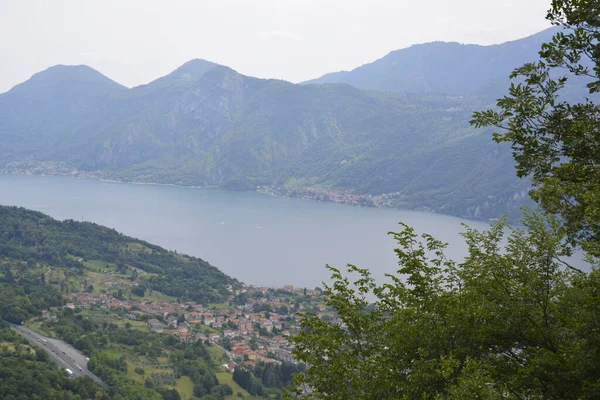 Panorama of mountain lake Como surrounded by green hills covered with cedar forest — Stock Photo, Image