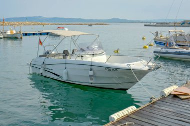 Rıhtımdaki beyaz motorlu tekne deniz yolculuğuna hazır.
