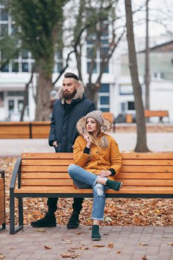 Bir adam ve bir kız sonbahar parkında bir bankta dinleniyorlar. Ceketli, sevgi dolu bir çift ana parktaki bankta oturuyor..
