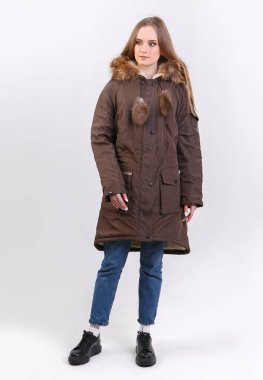 Beyaz arka planda kışlık ceket giyen genç bir kadın. Mağaza için fotoğraf tanıtımı kavramı.