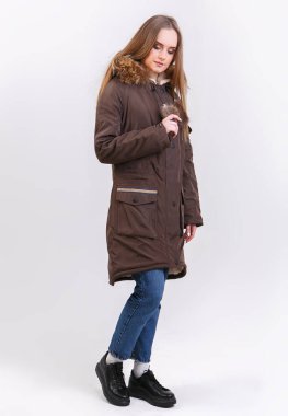 Beyaz arka planda kışlık ceket giyen genç bir kadın. Mağaza için fotoğraf tanıtımı kavramı.