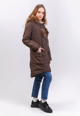 Beyaz arka planda kışlık ceket giyen genç bir kadın. Mağaza için fotoğraf tanıtımı kavramı.