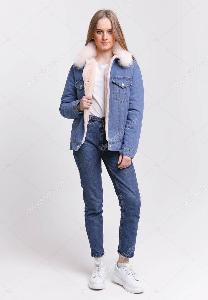Young Woman in a denim suit with a fur collar on a white background. Clothing advertising concept.