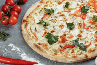 Domatesli tavuk mavisi pizza, mozzarella ve gri arka planda Dor Blue peyniri..