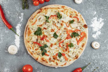 Domatesli tavuk mavisi pizza, mozzarella ve gri arka planda Dor Blue peyniri..