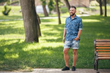 Bahar parkında yürüyen genç adam. Güneşli bir gün. Vesna. Komik adam. İyi bir ruh hali. Yürüyen portre.