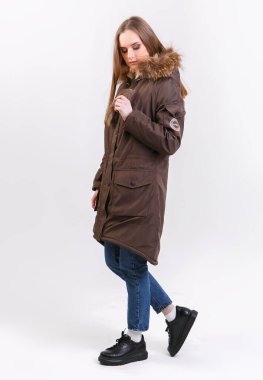 Beyaz arka planda kışlık ceket giyen genç bir kadın. Mağaza için fotoğraf tanıtımı kavramı.