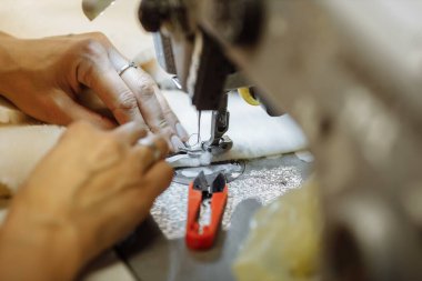 Dikiş makinesi kumaş karalıyor. Fabrikada terzilik..