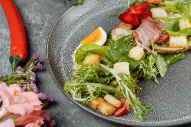 Dekorlu ve kopyalanmış gri tabakta sezar salatası.