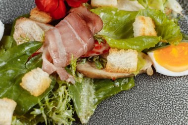 Dekorlu ve kopyalanmış gri tabakta sezar salatası.