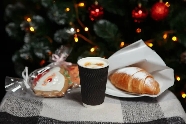 Рождественский кофе и круассаны с подарками и игрушками на фоне елки — стоковое фото