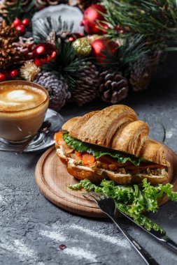 Kruvasanla yeni yıl kahvaltısı. Kırmızı balık ve avokado ile yeni yıl kruvasanı. Yeni yıl ve Noel konsepti.