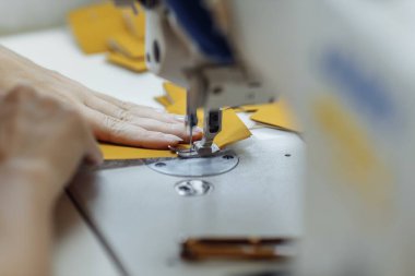 Dikiş makinesi kumaş karalıyor. Fabrikada terzilik..