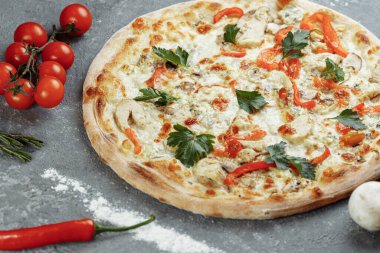 Domatesli tavuk mavisi pizza, mozzarella ve gri arka planda Dor Blue peyniri.