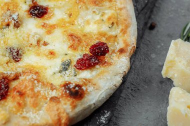 Sıcak dört peynir lezzetli ev yapımı Amerikan pizzası. Siyah masada kalın hamurlu..