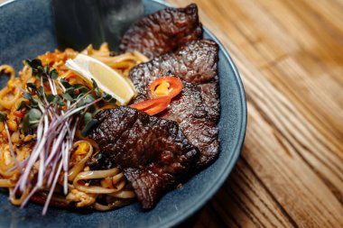 Erişteler, dana eti ve sebzeler gri masada..