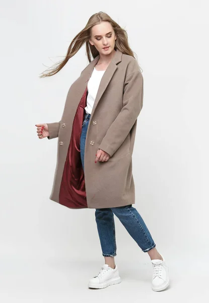 아름다운 모델이 갈색긴 코트를 배경으로 포즈를 취합니다 스튜디오 광고의 옷차림 — 스톡 사진