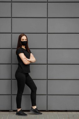 Coronavirus sırasında tıbbi maske takan güzel bir kız. Gri bir arka planda fotoğraf. Coronavirus Covid-19 'a karşı koruma