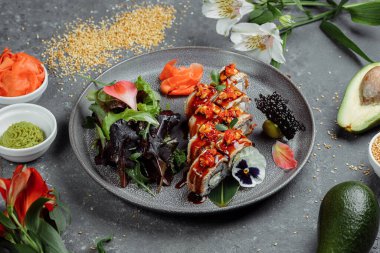 Geleneksel Japon yemekleri. Suşi gri arka planda yılan balığıyla yuvarlanır. bir yazıt için yer.