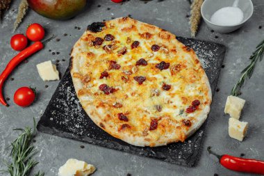 Sıcak dört peynir lezzetli ev yapımı Amerikan pizzası. Siyah masada kalın hamurlu.