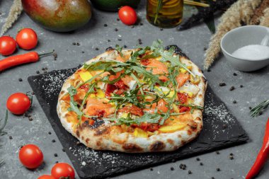 Somon ve sebzeli lezzetli pizza. İtalyan pizzası.