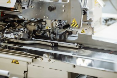 Dikiş makinesi kumaş karalıyor. Fabrikada terzilik..