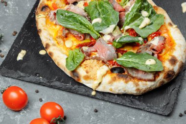 Etli İtalyan pizzası, biftek dilimleri, erimiş peynir, zeytin dilimleri ve çedar peyniri. Yaklaş, makro. Pizza zamanı konsepti