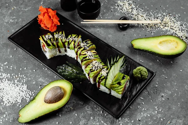 Zöld sárkány sushi tekercs angolna, avokádó, uborka és gyömbér, kíséretében sült tempura garnélarák. Hagyományos ázsiai rizs sushi egészséges tengeri ételek — Stock Fotó