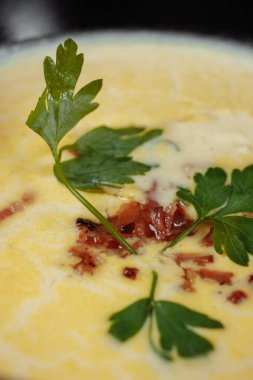 Gri arka planda siyah tabakta peynir çorbası..