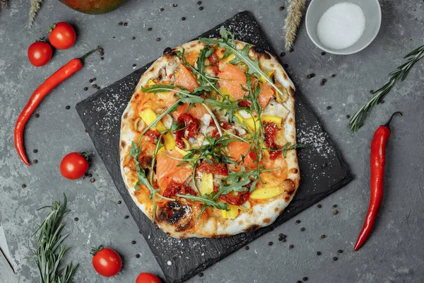 Somon ve sebzeli lezzetli pizza. İtalyan pizzası..